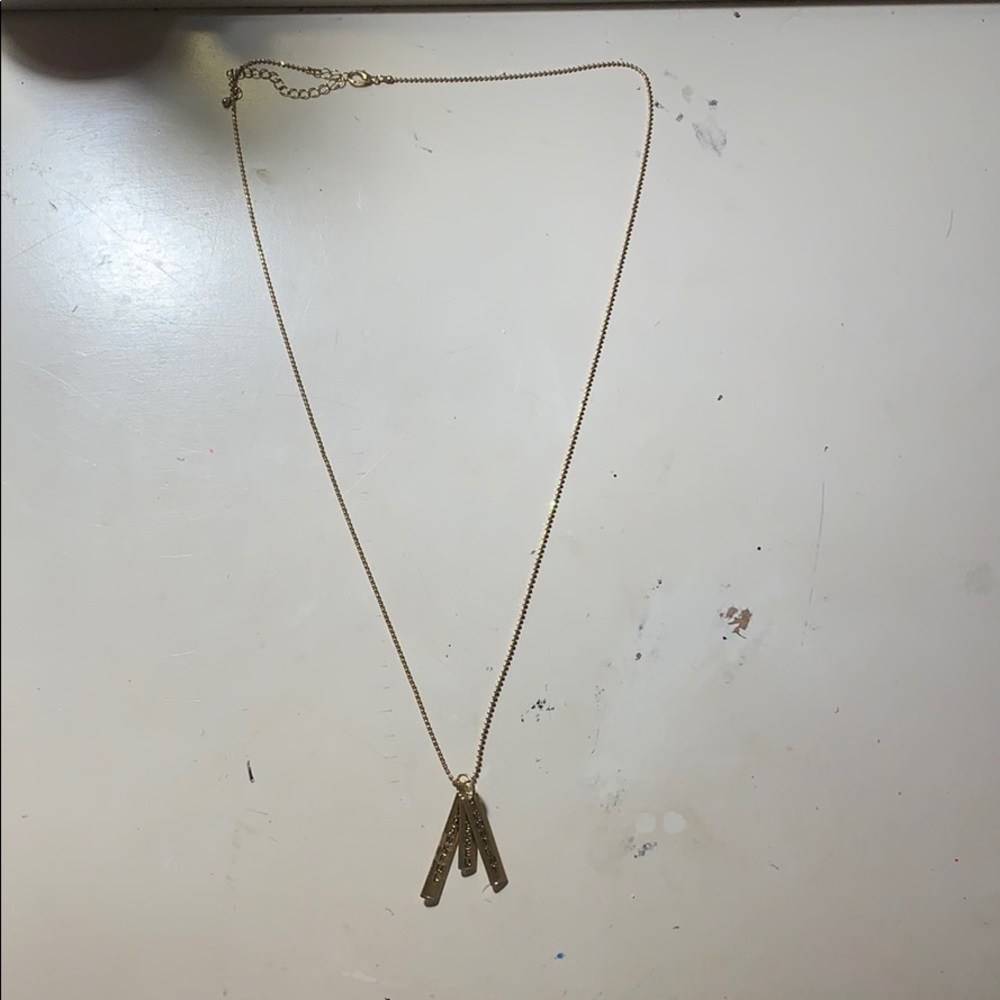 gold necklace that has 3 charms